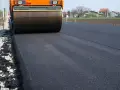 Walec drogowy ubija świeży asfalt. Zastanawiasz się, ile kosztuje asfalt na podjazd?