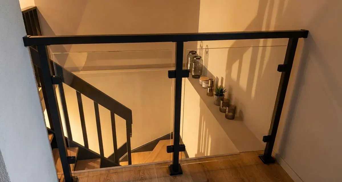 Nowoczesna balustrada ze szkła i czarnego profilu, idealna do schodów. Pokazuje, jak zrobić balustradę z profila.